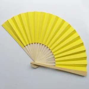 Close-up view of a bright yellow bamboo folding fan showing the texture and structure.