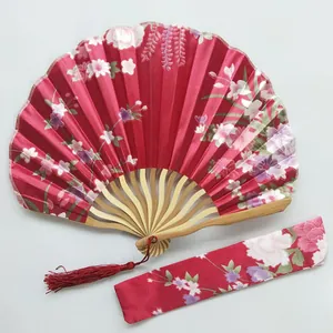 Detailed view of red floral satin kimono fan with bamboo ribs and matching fabric sleeve.