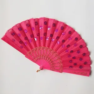 Macro detail of a bright pink folding fan with shimmering purple sequins and gold lace.