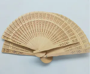 Vista detallada del intrincado patrón floral calado en un abanico plegable de madera
