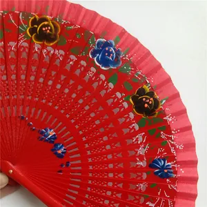 Detalle de flores pintadas a mano en un abanico de madera español rojo