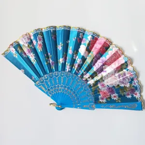 Macro detail of blue satin folding fan featuring floral patterns and delicate lace trim