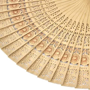 Primer plano detallado de un abanico plegable de madera tallada con motivos de girasol