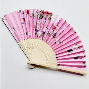 Close-up of pink Japanese folding fan with elegant cherry blossom floral patterns