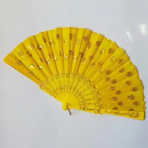Macro detail of a bright yellow sequin folding fan with elegant gold embroidery and floral motifs