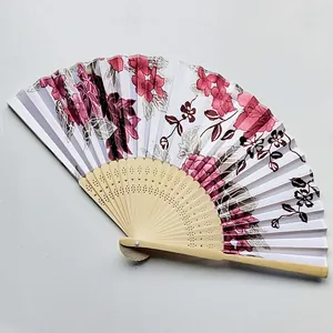 Detail view of traditional Japanese folding fan with pink floral pattern on satin cloth