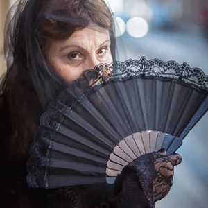 Elegante ventaglio spagnolo nero con pizzo tenuto da una modella con velo nero