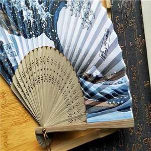 Primer plano detallado del estampado ukiyo-e Gran Ola en un abanico plegable de bambú tradicional