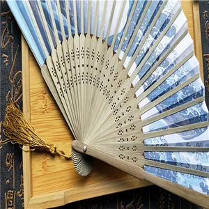 Detalle de un abanico plegable japonés con varillas de bambú y diseño de gran ola