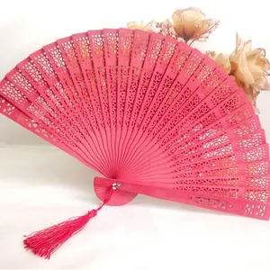 Elegante abanico plegable de madera tallada con borla decorativa en color rosa vibrante