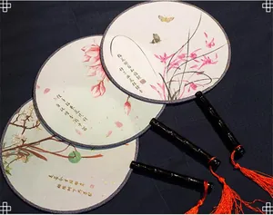 Macro detail of ancient Chinese style round fans with silk floral patterns and tassels