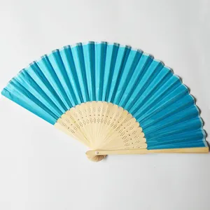 Detailed view of a bright blue silk folding fan with an ornate carved bamboo frame