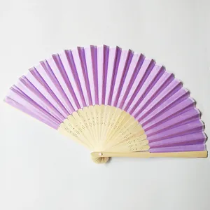 Detailed close-up view of a purple silk folding fan with a hollowed bamboo frame.