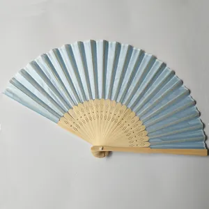 Detailed view of light blue silk folding fan with intricate hollowed bamboo ribs.