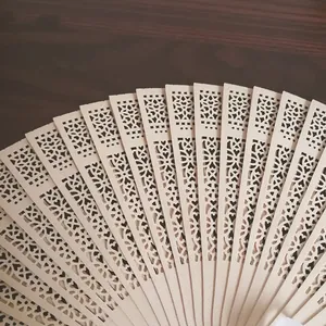 Primer plano de un abanico plegable de madera tallada con delicados motivos de corazón