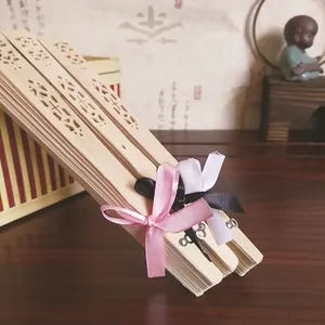 Vista detallada de abanicos de madera tallada con elegantes lazos de cinta para bodas.