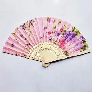 Detailed macro view of pink floral print silk folding fan with carved bamboo frame