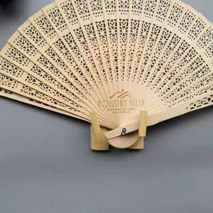 Detalle de un abanico de madera cortado con láser con patrones calados y un grabado personalizado