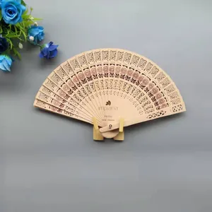 Detalle de abanico de madera grabado con elegantes motivos florales.