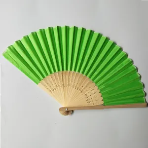 Detailed view of a vibrant green silk folding fan featuring carved bamboo ribs