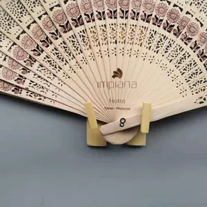 Detalle de un abanico plegable de madera tallado a mano para regalos de boda exclusivos