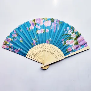 Close-up detail of blue floral print Japanese folding fan with carved bamboo ribs