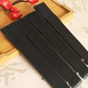 Detail view of black bamboo folding fans on a traditional tray