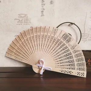 Vista detallada de un abanico plegable de madera tallada con motivos de girasol y cinta blanca