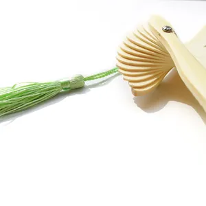 Primer plano de varillas de abanico plegable con elegante borla verde