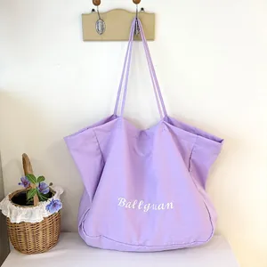 Lavender canvas tote bag hanging on a hook with embroidered text and floral basket
