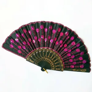 Detailed view of Spanish style folding fan with pink sequin embroidery and peacock pattern