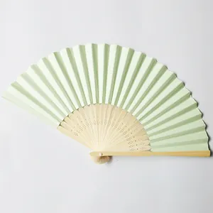 Detailed view of a blank beige paper fan with carved bamboo ribs for DIY crafts.