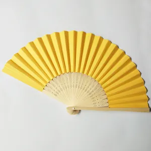 Detailed view of a bright yellow blank paper folding fan with wooden ribs