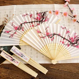 Close-up detail of a traditional silk folding fan featuring ink plum blossom painting