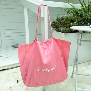 Large pink Harajuku style tote bag with white Ballguan embroidery hanging outdoors