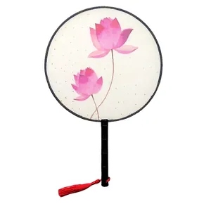 Close-up detail of a traditional Chinese round fan with pink lotus and red tassel