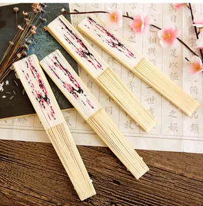 Close-up of four oriental silk folding fans with plum blossom ink painting patterns