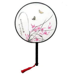 Close-up of traditional Chinese round fan with floral ink painting and red tassel