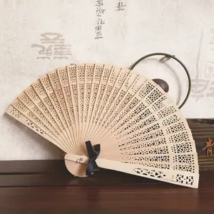 Vista detallada de un abanico plegable de madera tallada con patrón de girasol