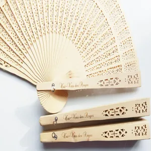 Primer plano de abanicos de madera grabados personalizados para bodas con diseño calado