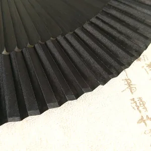 Macro detail of premium black silk pleats and bamboo ribs on a traditional folding fan