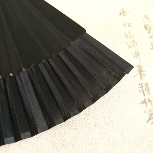 Detailed close-up of the black bamboo ribs and fine fabric texture of a folding fan