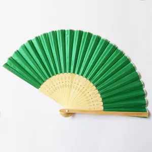 Close-up of a green silk folding fan with traditional carved bamboo frame