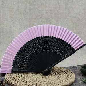 Elegant pink and black hollow bamboo folding fan in traditional oriental style