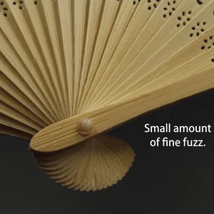 Close-up detail of handcrafted bamboo folding fan with hollow pattern.