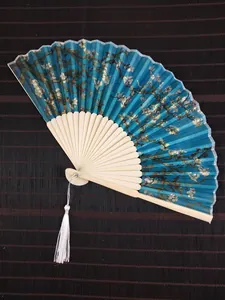 Detailed macro view of Almond Blossom print folding fan with elegant white tassel decoration.