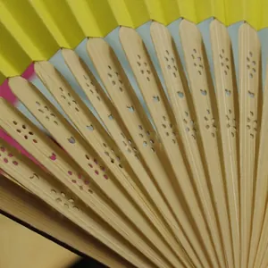Professional macro view of a traditional Chinese silk folding fan with carved bamboo ribs
