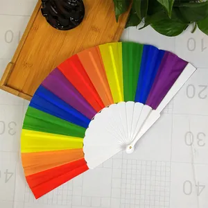 Vibrant rainbow folding fan with white plastic handle on a measurement grid.