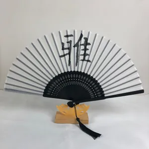 Détail d'un éventail pliant chinois avec calligraphie sur un support en bois