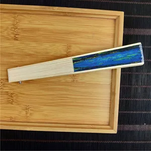 Folded bamboo silk fan featuring Monet's Impression Sunrise painting on a wooden tray
